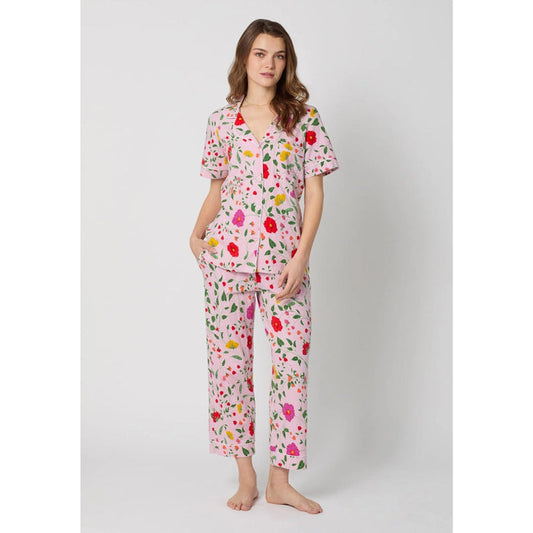 Woman wearing a floral pajama set on a white background