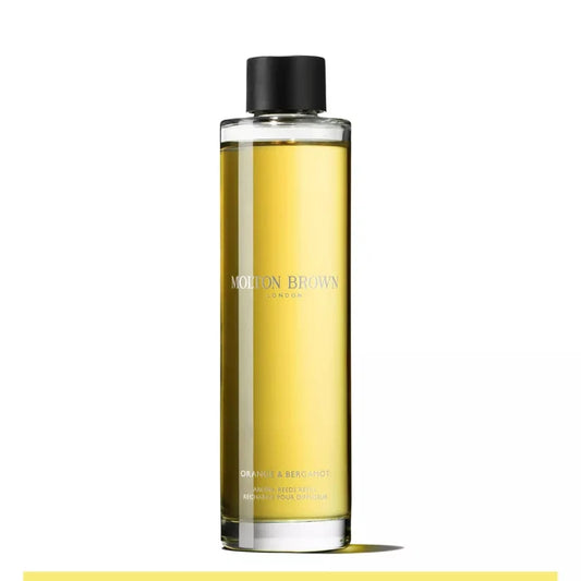 A clear glass bottle with yellow liquid and black cap, labeled Molton Brown