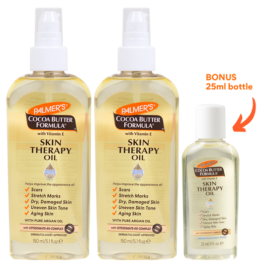 Three bottles of Palmer's Cocoa Butter Formula Skin Therapy Oil shown on a white background, with a bonus 25ml bottle indicated by an orange arrow and text.