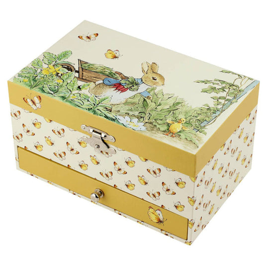 A decorative wooden storage box with two drawers, featuring a Peter Rabbit illustration on the lid and a pattern of small bees on a cream background with mustard yellow sides.