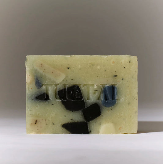 Bar of soap with TU ET AL brand name on a neutral background